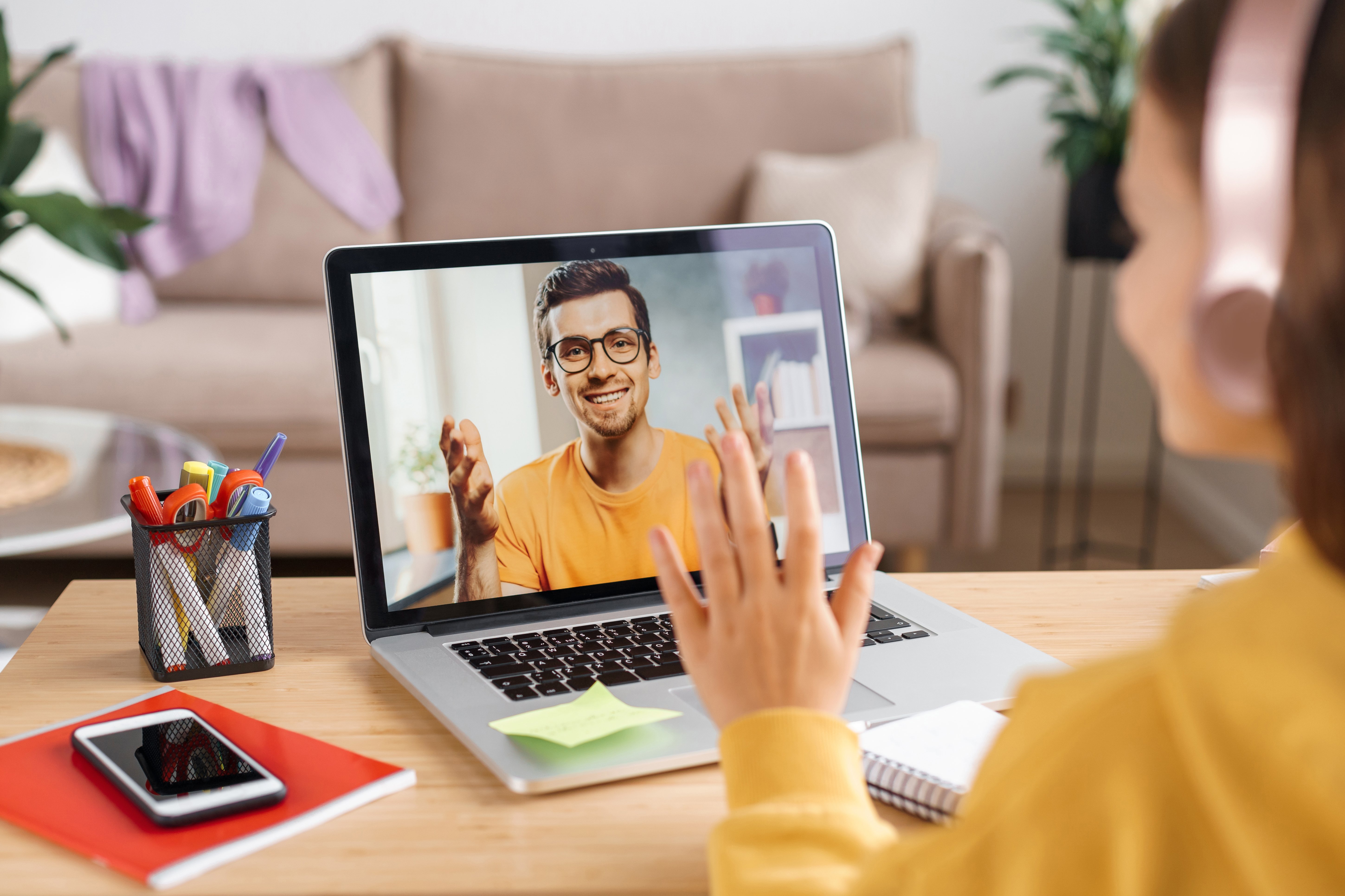 girl-in-headphones-waving-hand-to-online-teacher-2023-11-27-04-49-49-utc